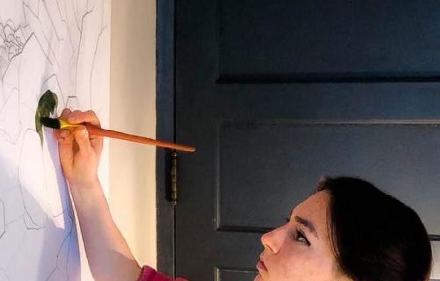 Undergraduate student, Raisa Kochmaruk shown painting artwork on a wall