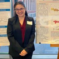 A portrait of Rachael Shippee standing next to a research poster.