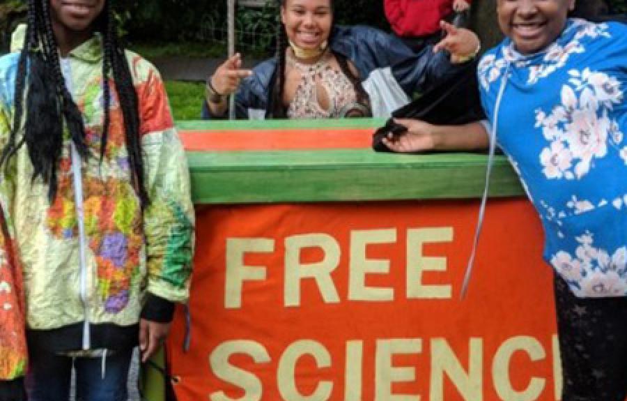 Three young students with a sign that says: &quot;Free Science.&quot;