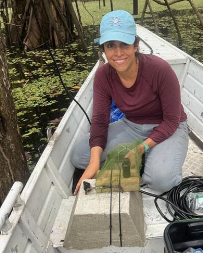 A portrait of Marisol Valverde Montellano in a canoe doing field research.