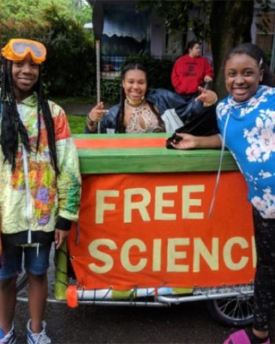 Three young students with a sign that says: &quot;Free Science.&quot;